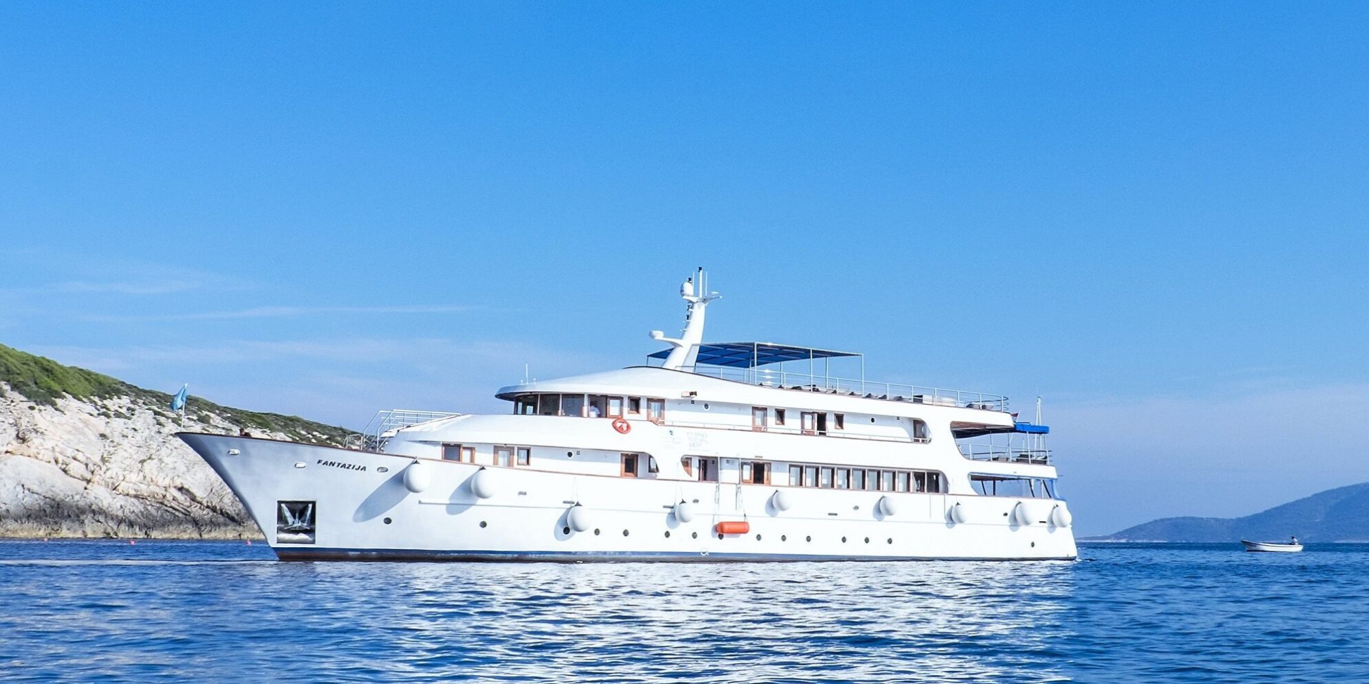 Passengers enjoying a swimming stop during an affordable Croatian journey in a secluded bay